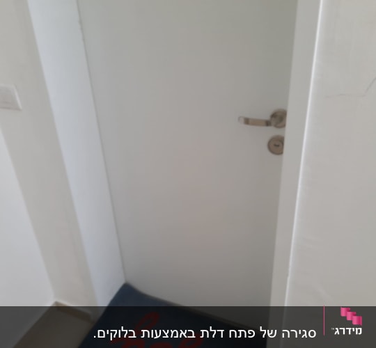 דלת לבנה עם ידית מתכת, קיר צבוע